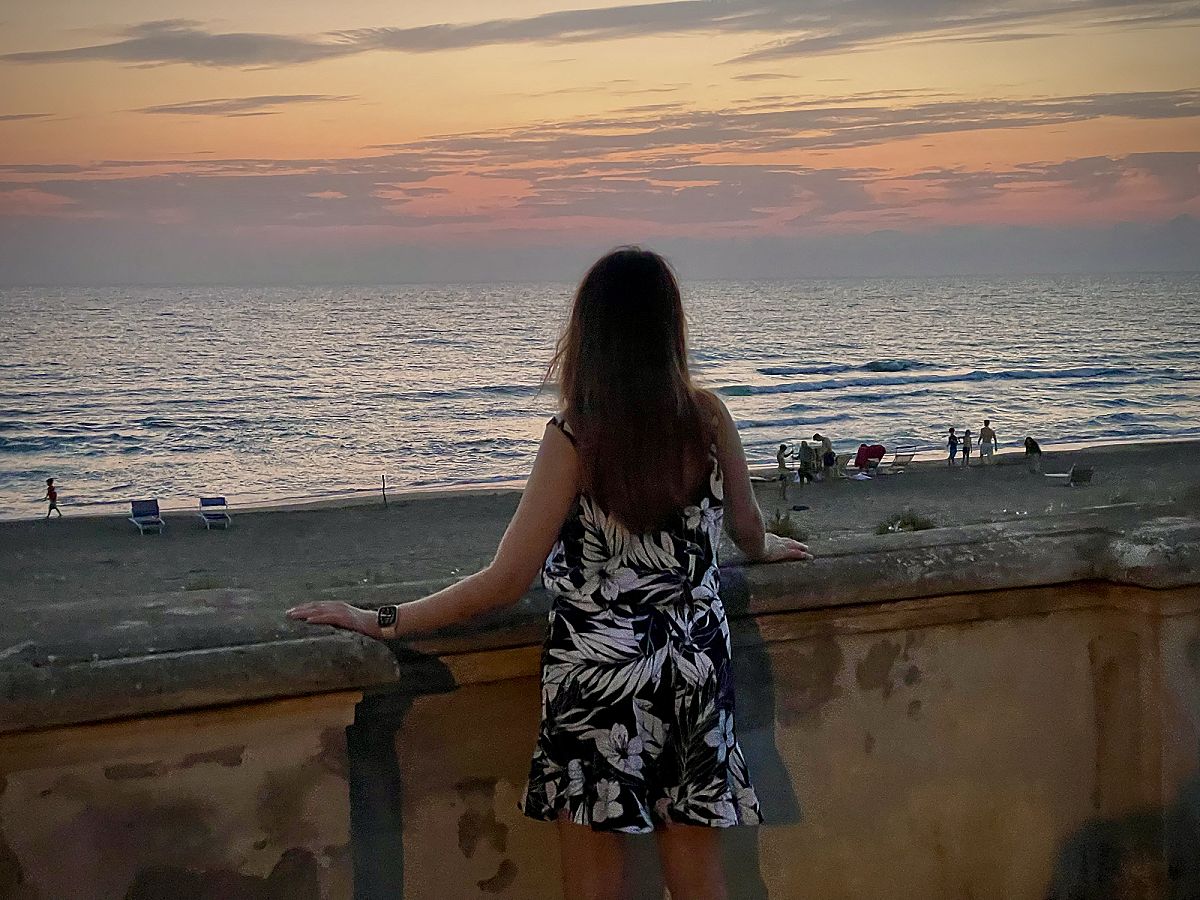 Il mare al tramonto visto da un muretto sul lungomare