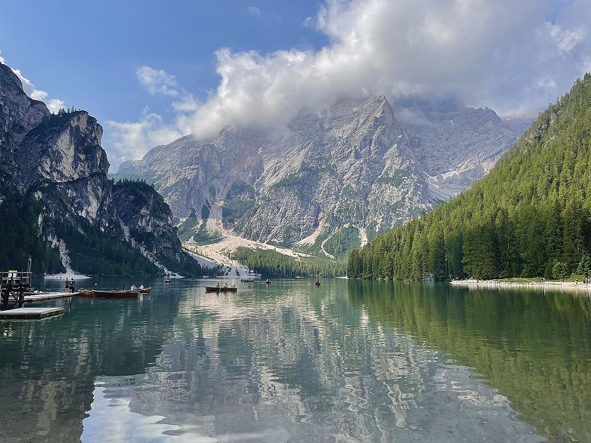 Il Lago di Braies dalla riva, con le montagne riflesse nell'acqua ferma