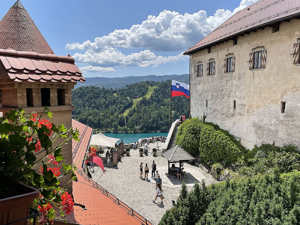 Il castello di Bled dall'alto, con la bandiera slovena e il lago sullo sfondo
